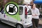 Emily Curley from the Office of Sustainability poses next to AU's newest vehicle,an electric car for use between Tenley Campus and main campus.